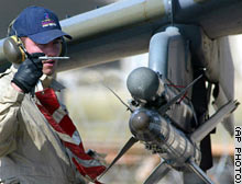 A Royal Air Force ground crewman pulls the safety pin from a Sidewinder missile as final arming of the aircraft is carried out in Kuwait.